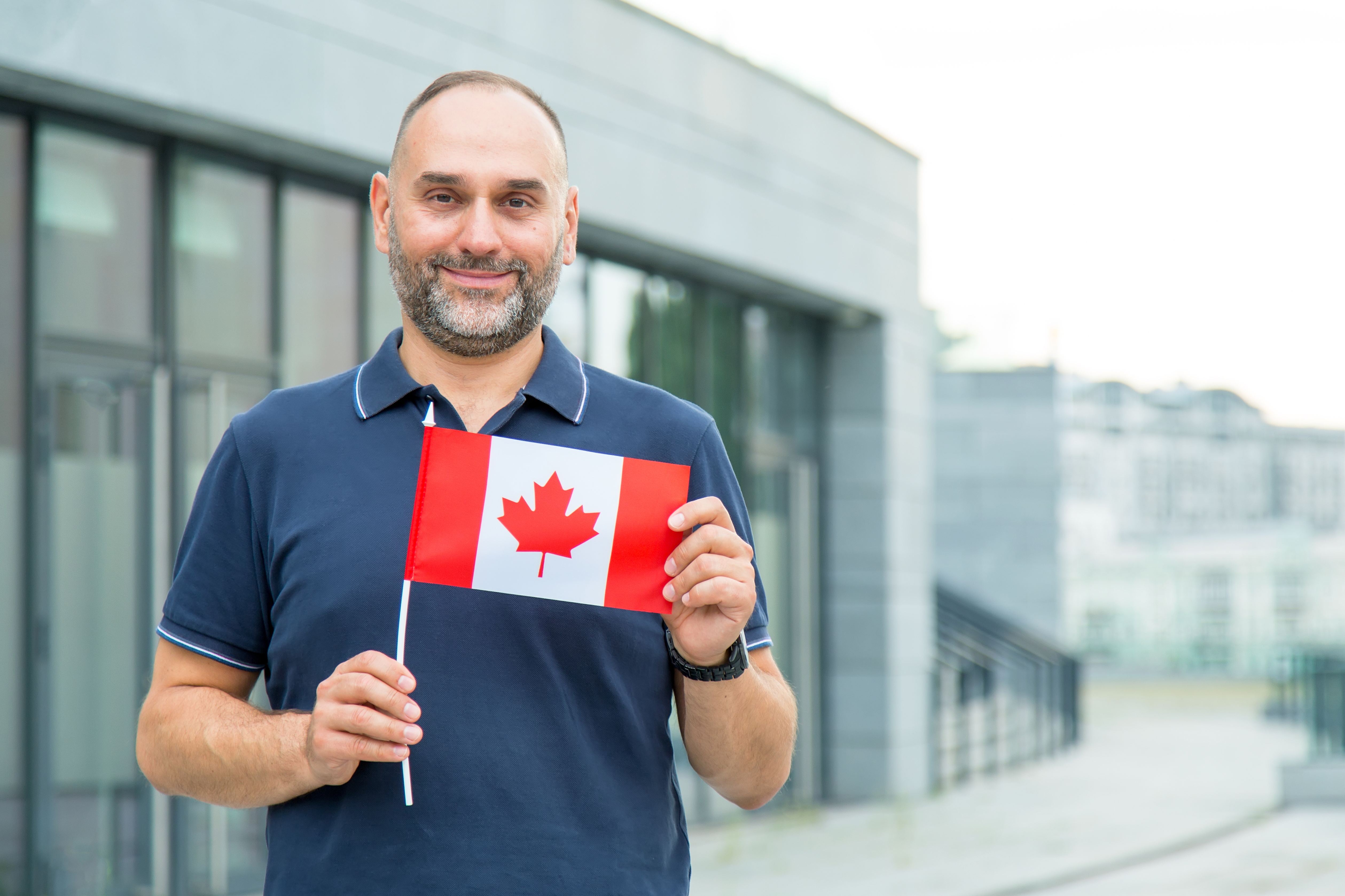 Мужчина с флагом Канады, где он может получить рабочую визу